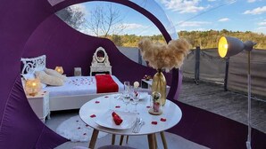 A circular tent with a bed, a dining table, and a chair. - La Bulle Des Anges (Dormir à la belle étoile) (Illoud)