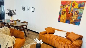 A living room with a sofa, coffee table, and a painting on the wall.