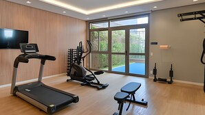 A modern home gym with a treadmill, exercise bike, bench, and weight machines. - Prime Smart Santa Cruz (São Paulo)