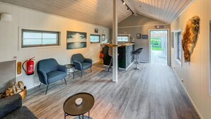A modern interior with a wooden ceiling, a bar area, and a view to the outside. - Lovely home in Flekkefjord with sauna (Flekkefjord)