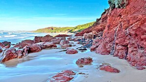 A rocky beach with large boulders and a clear view of the ocean. - Infinity at Surf Beach (Surf Beach)