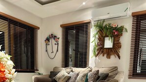 Una sala de estar moderna con un sofá, una mesa de centro de madera y un espejo decorativo.