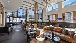 A spacious lobby with a bar area, seating arrangements, and large windows providing views. - Luxury Mountain Resort (Park City)