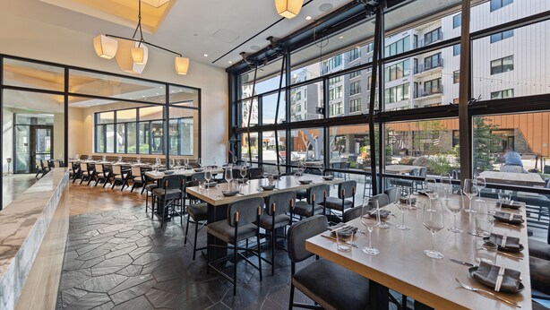 A restaurant with large windows, modern interior design, and a stone-tiled floor. - Luxury Mountain Resort (Park City)