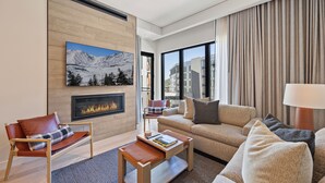 A modern living room with a fireplace, a sofa, a chair, and a coffee table. - Luxury Mountain Resort (Park City)