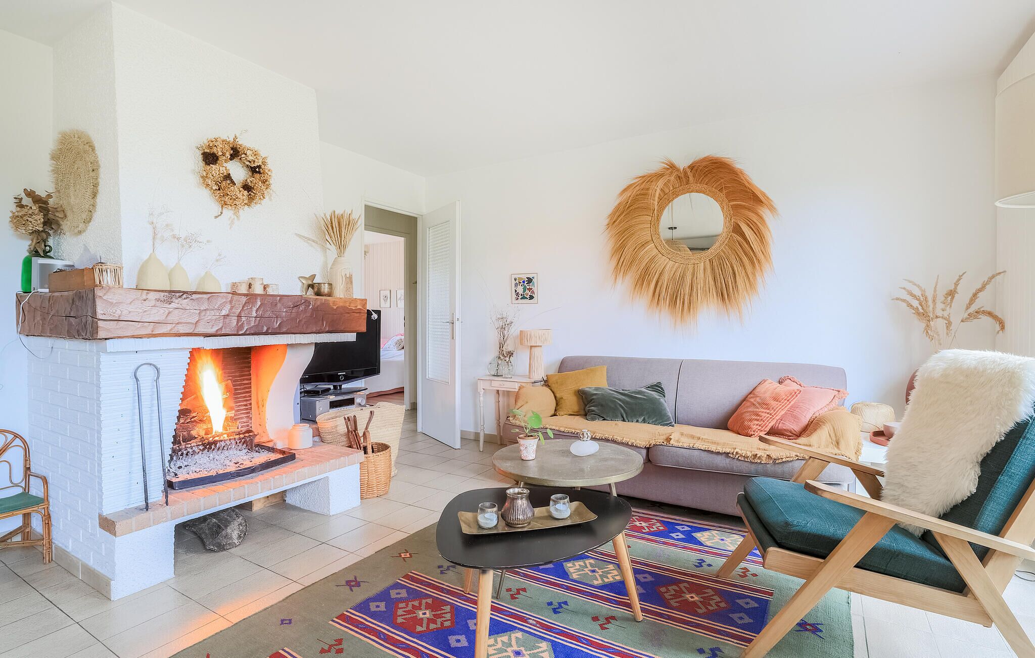 A cozy living room with a fireplace, a sofa, a coffee table, and a chair.