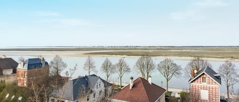 Ein Wohngebiet mit Häusern, einem Fluss und einer fernen Küstenlinie.