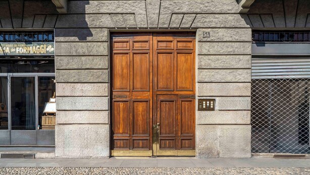 A large wooden double door with a brass handle, set in a stone building facade. - Milano Apartments Alzaia 54 (Milan)