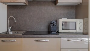 A modern kitchen with a stainless steel sink, a built-in microwave, and a kettle. - Milano Apartments Alzaia 54 (Milan)