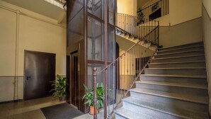 A staircase with a wooden handrail and metal balusters, leading to an upper floor. - Milano Apartments Alzaia 54 (Milan)