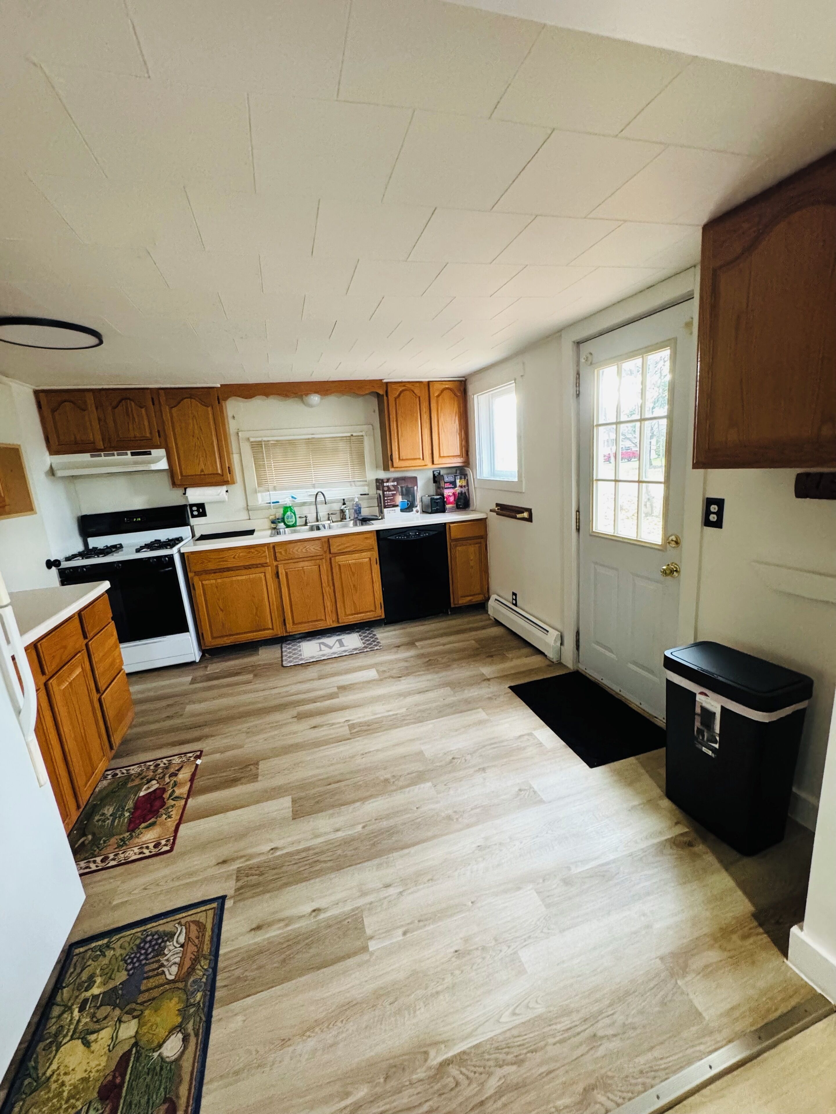 A kitchen with wooden cabinets, a stove, and a dishwasher.
