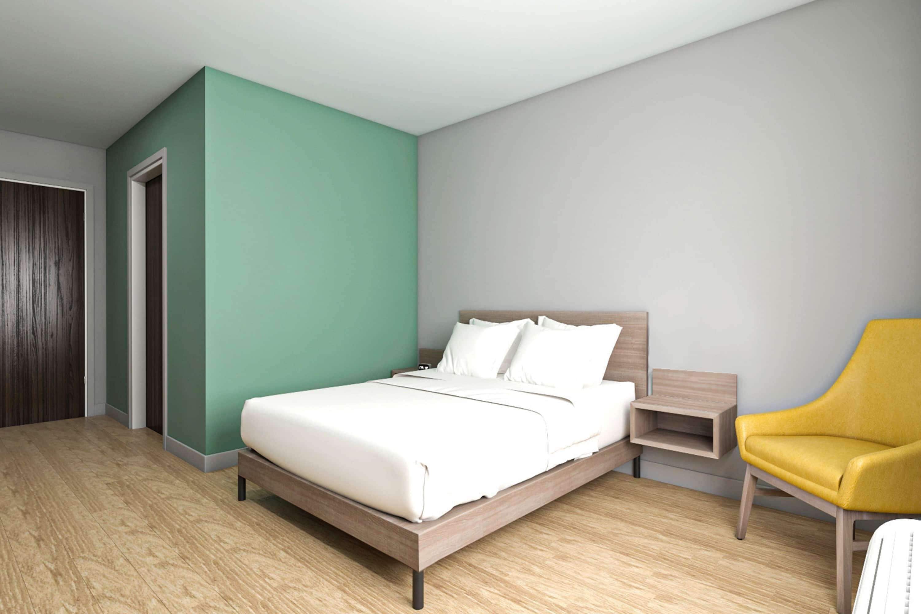 Un dormitorio moderno con una cama de madera, un sillón amarillo y una mesita de noche.