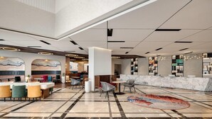 A spacious lobby with a marble floor, seating areas, a reception desk, and a large mural on the wall. - Ramada Encore By Wyndham Rajbagh Srinagar (Srinagar)