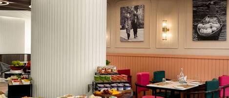 A buffet with various food items and a seating area with chairs and tables.