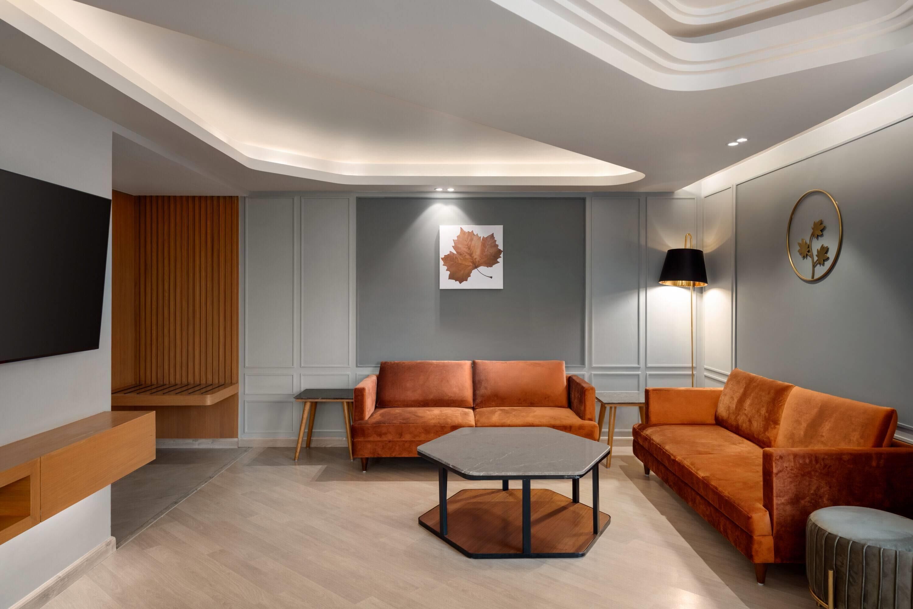 A modern living room with a sofa, a coffee table, and a TV mounted on the wall.