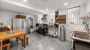 Eine moderne Küche mit Edelstahlgeräten, einem Holzespeisetisch und einem eingebauten Backofen.