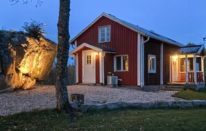 A red wooden house with a white door and windows, a porch, and a stone wall. - 3 bedroom stunning home in Backaryd (Backaryd)
