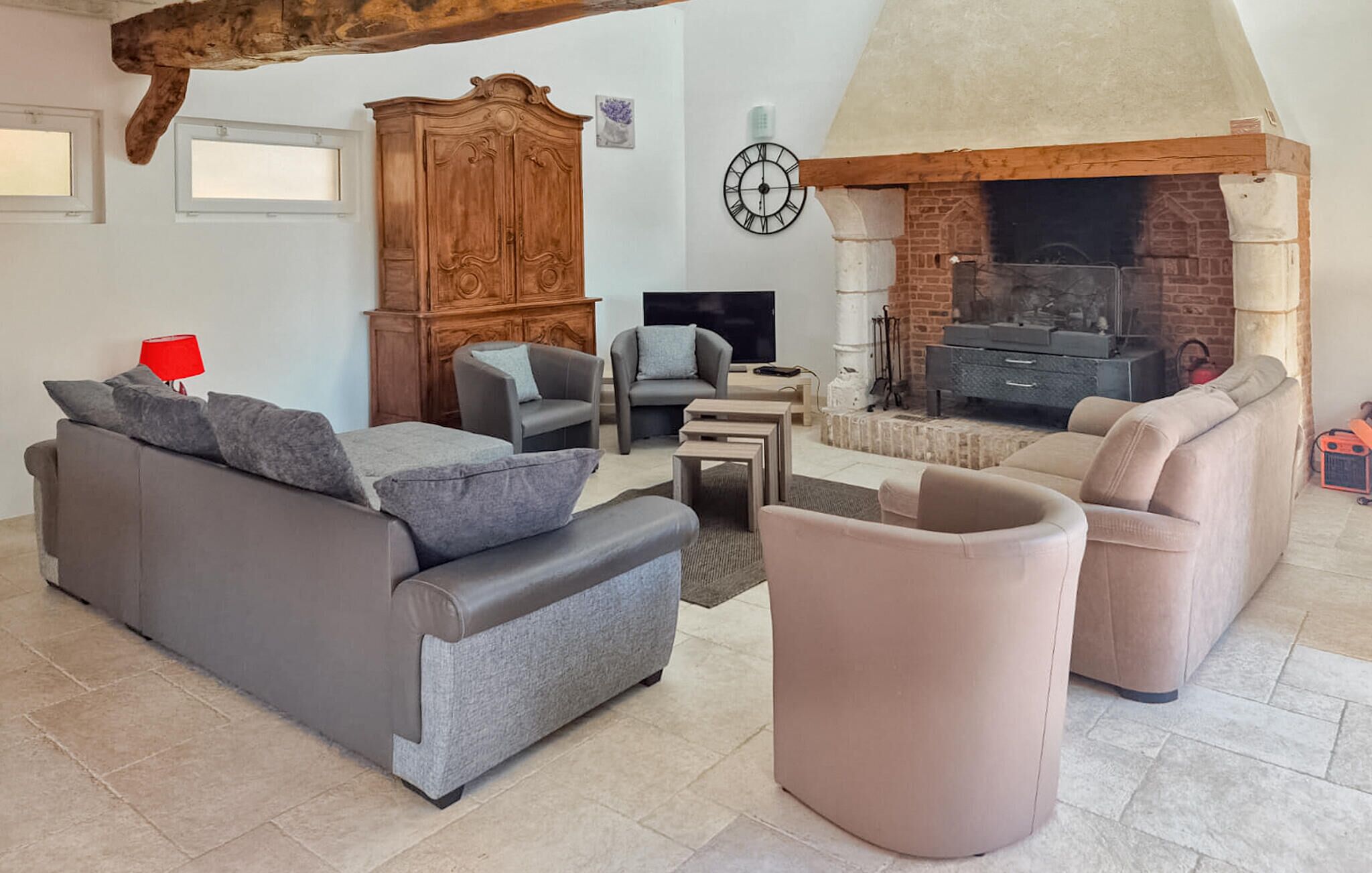 Ein Wohnzimmer mit Kamin, Sofas, Fernseher und einer Holzeinrichtung.