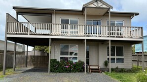 Une maison à deux étages avec un porche couvert et un balcon.