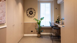 A modern kitchen with a large wall clock, a window, and a potted plant. - Your room like in a 4-star Hotel (Roma)