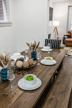 A dining table set with plates, bowls, and decorative items.