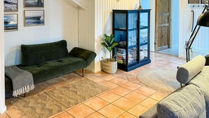 Ein Wohnzimmer mit einem grünen Sofa, einem blauen Schrank und einer Stehlampe.