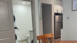 Una cocina moderna con un refrigerador de acero inoxidable, una mesa de comedor de madera y sillas.