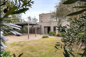A modern two-story building with a covered patio area and a well-maintained lawn.