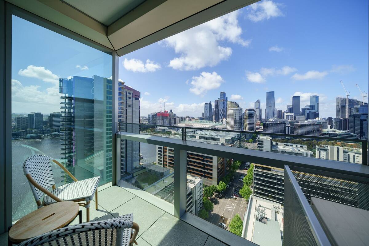 A balcony with a city view, including modern buildings and a bridge.
