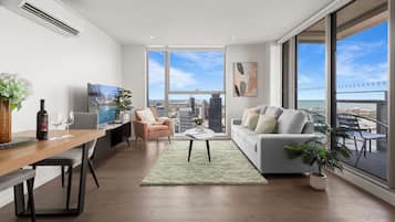 Departamento ejecutivo, 3 habitaciones, balcón, vista a la ciudad | Área de sala de estar | Smart TV