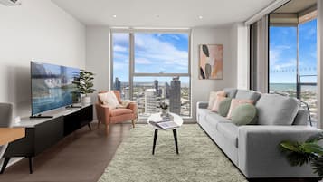 Departamento ejecutivo, 3 habitaciones, balcón, vista a la ciudad | Área de sala de estar | Smart TV