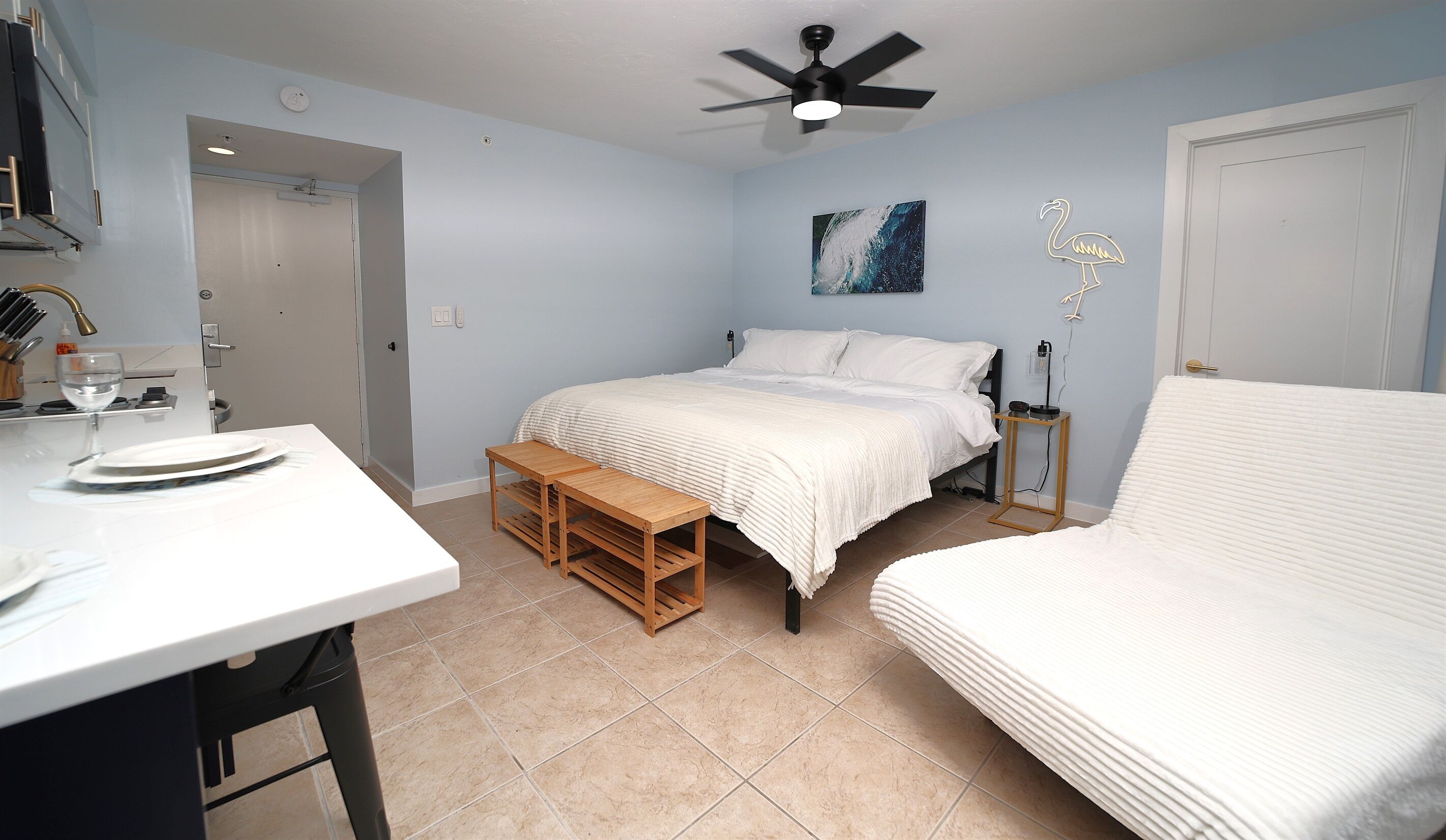 A bedroom with a bed, bedside table, and a small wooden bench.