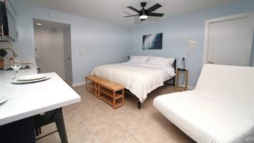 A bedroom with a bed, bedside table, and a small wooden bench.