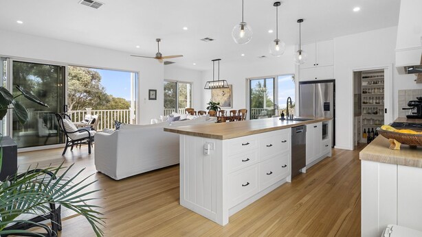 A spacious kitchen with a central island, large windows, and a dining area with a view. - The White House - 6 Bennett Street (CARRICKALINGA)