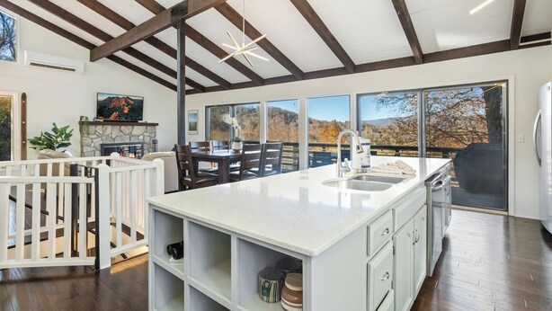 Una cocina espaciosa con una isla grande, vigas de madera y vistas al exterior.