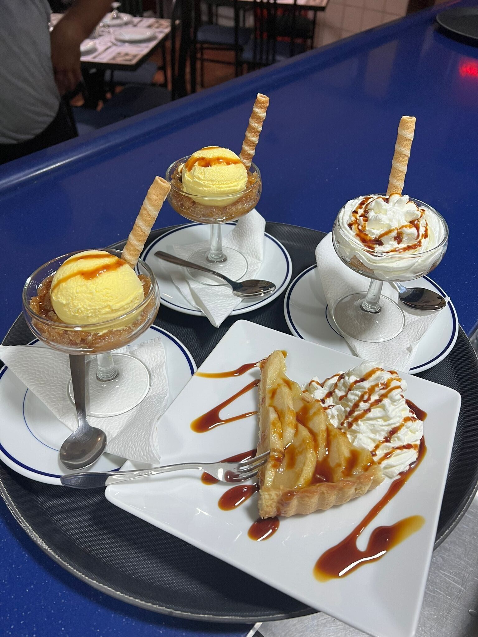 Assortiment de desserts avec de la crème glacée et de la sauce au caramel, présentés sur un plateau.