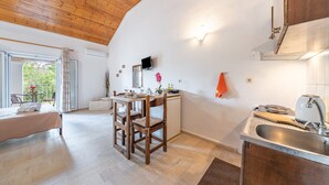 Cozinha moderna com teto de madeira, área de jantar com mesa e cadeiras, e vista pela janela aberta.