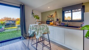 Una cocina moderna con comedor, un ventanal y vistas al exterior.