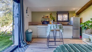 Una cocina compacta con comedor, un refrigerador y ventana con vistas a un jardín.