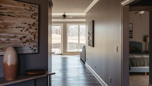A hallway with a ceiling fan, a large window, and a bed in the adjacent room. - Stunner Golf Course View | Walkable to Club House (Marion)