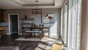A spacious living area with a dining table, chairs, and a large window providing natural light. - Stunner Golf Course View | Walkable to Club House (Marion)