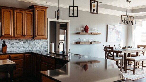 A modern kitchen with wooden cabinets, a large island, and pendant lighting. - Stunner Golf Course View | Walkable to Club House (Marion)