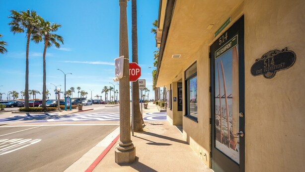 A street view with a 'No Turns' sign, palm trees, and a building with a sign reading '514 East Oceanfront'. - Clean Budget Friendly Apartment Steps from Beach (Newport Beach)