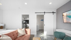 A modern living room with a sofa, a coffee table, and a TV wall-mounted above a seating area.