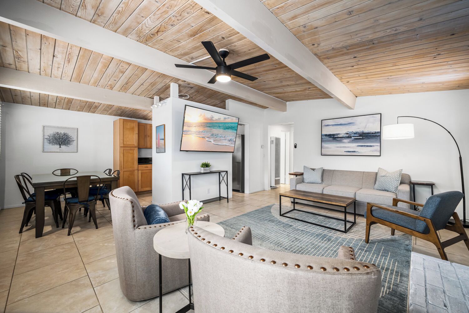 A spacious living room with a high ceiling, a dining area, and a kitchen.