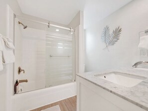 Ein modernes Badezimmer mit einer gläsernen Dusche, einem мраморном Waschbecken und einem Handtuchhalter.