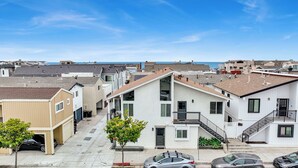 Una zona residencial con casas que presentan una variedad de estilos arquitectónicos, incluyendo una casa blanca destacada con balcón y garaje.