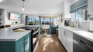 A modern kitchen with a central island, built-in appliances, and a view to the outdoors.