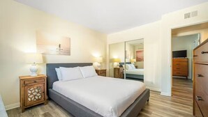 Ein Schlafzimmer mit Bett, Nachttischen, einem Spiegel und einer Kommode.