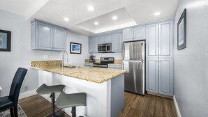 Una cocina moderna con encimeras de granito, electrodomésticos de acero inoxidable y armarios azul claro.